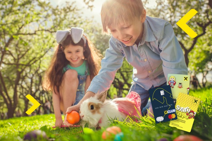 Zwei Kinder und Kaninchen beim Osternest suchen, daneben Raiffeisen Debitkarten im Kinder-Design